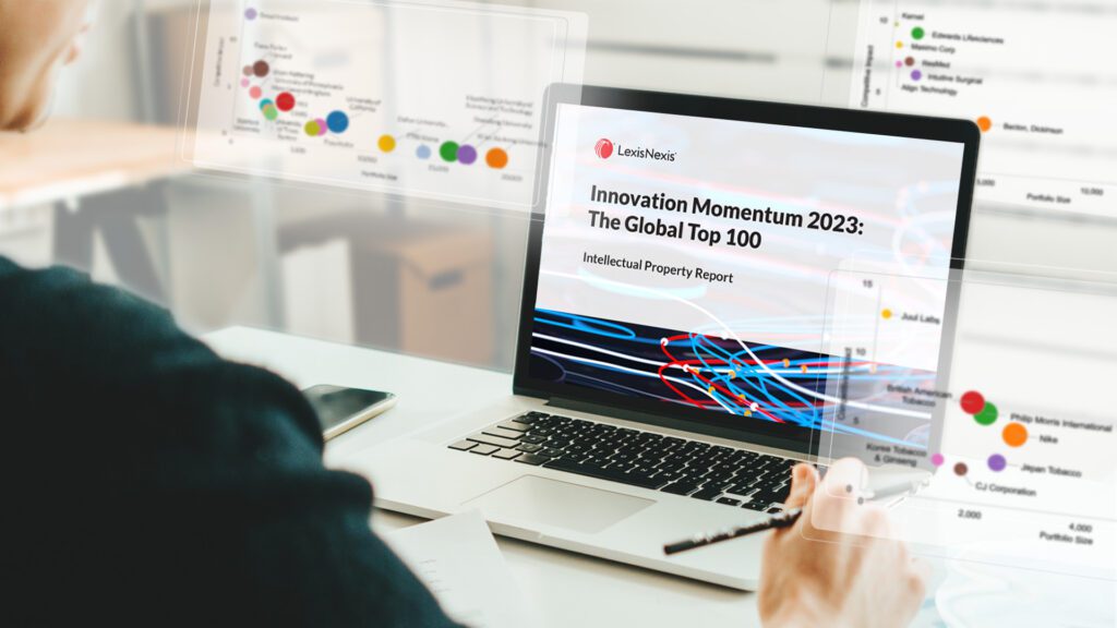 Professional viewing the Innovation Momentum 2023 report with graphs coming out of the computer screen